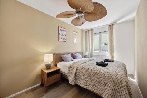 a bedroom with a bed and a ceiling fan at UP&GREAT Apartments - Stylish City Living in Zürich
