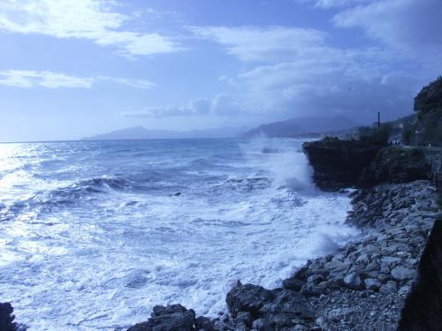 a large body of water with waves crashing on a rocky shore at Appartamento fronte spiaggia in Cavi di Lavagna