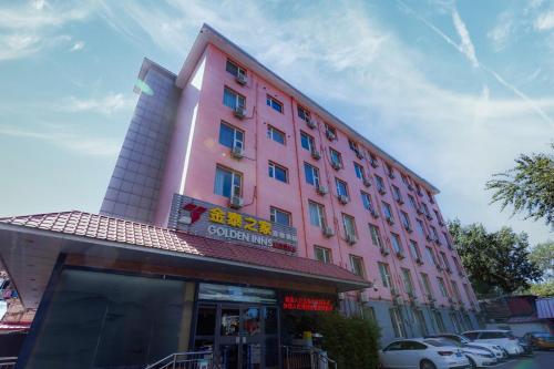 ein rosa Gebäude mit davor geparkten Autos in der Unterkunft Golden Inns Beijing South Railway金泰之家北京南站店 in Peking