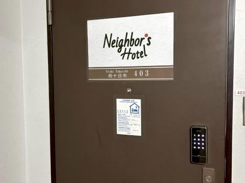 a metal door with a sign on it at Neighbor's Hotel 西十日市 in Hiroshima