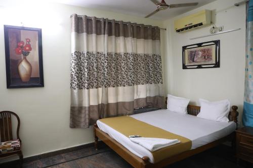 a bedroom with a bed and a curtain at Welcome Stay in Singapperumālkovil