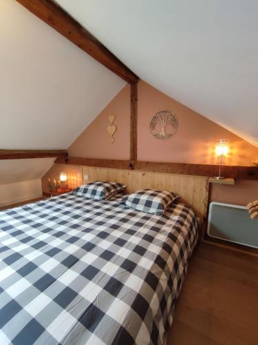 une chambre avec un grand lit dans un grenier dans l'établissement Le refuge chic, à Luchon