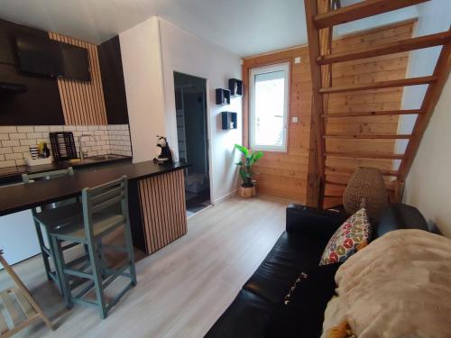 - un salon avec un canapé en cuir noir et un bar dans l'établissement Le refuge chic, à Luchon