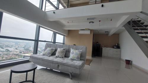 a living room with a couch and some windows at Cozy Loft, Pinnacle PJ#5 (3pax) in Petaling Jaya