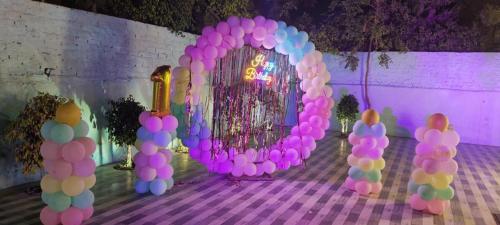 a bunch of pink and purple balloons in front of a doorway at Aroma Green Farm Manesar with Pool in Bahora