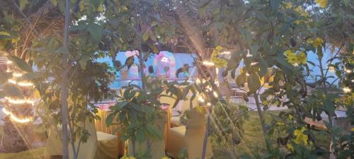 a garden with trees and lights in the background at Aroma Green Farm Manesar with Pool in Bahora