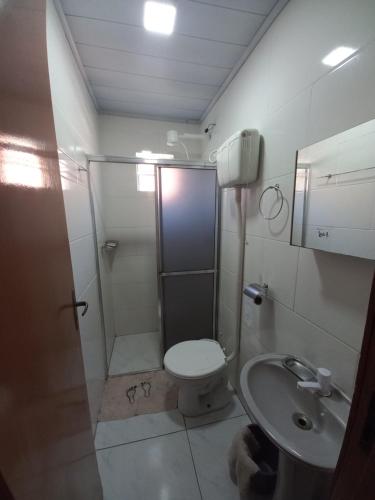 a bathroom with a shower and a toilet and a sink at Cabana Caminho de Pedras in Montenegro