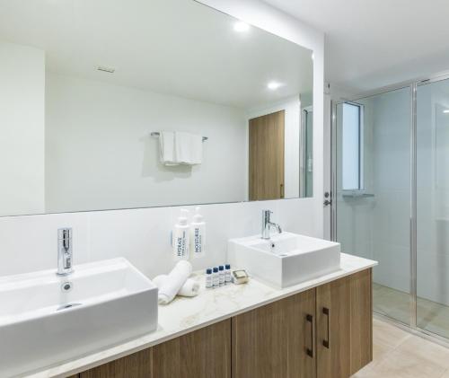 a bathroom with two sinks and a mirror at Oaks Port Douglas Resort in Port Douglas