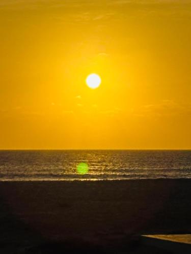 a sunset on the beach with the ocean at Stay, laugh, repeat! in Prainha