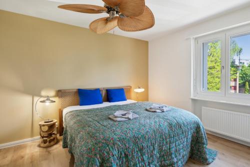 a bedroom with a bed with a ceiling fan at UP&GREAT Apartments - Stylish City Living in Zürich