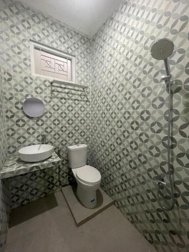 a bathroom with a toilet and a sink and a shower at Villa Sukun in Yogyakarta