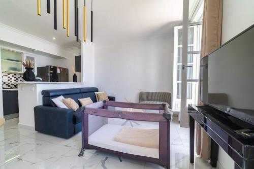 un salon avec un canapé bleu et une télévision dans l'établissement Appartement luxueux à la joliette avec vue Mer, à Marseille