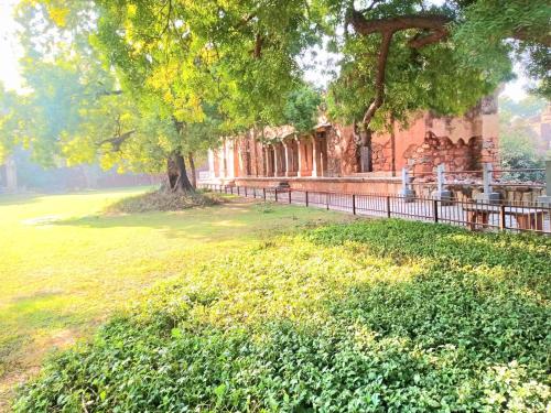 un parque con un árbol y una valla en Blueberry Residency, en Nueva Delhi