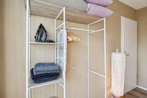 a walk in closet with white shelving at UP&GREAT Apartments - Stylish City Living in Zürich