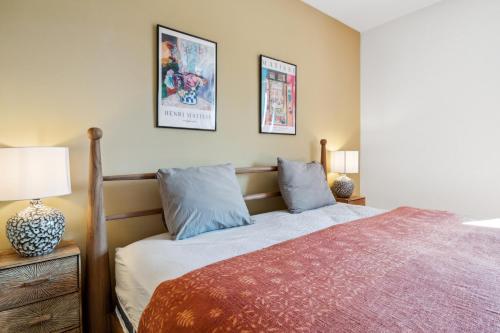 a bedroom with a bed and two pictures on the wall at UP&GREAT Apartments - Stylish City Living in Zürich