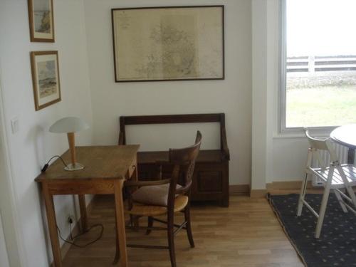 Cette chambre comprend un bureau, une table et des chaises. dans l'établissement Sea View Apartment, à Carnac