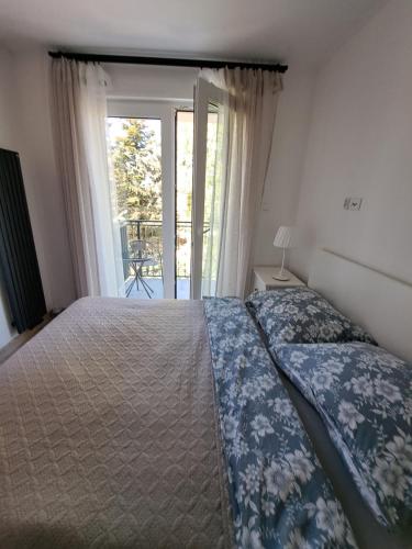 a bedroom with a bed and a window with a balcony at Arinea in Łeba