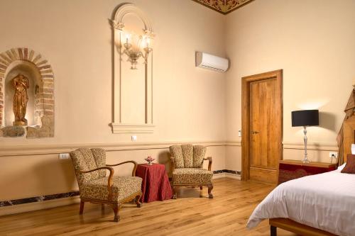 a bedroom with a bed and two chairs and a table at Palazo dei CONTI in Split Centre OLD town in Split