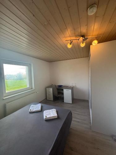 a room with a bed and a desk and a window at Bockhorn Farmhouse in Bockhorn