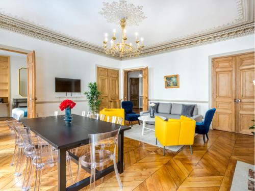 une salle à manger et un salon avec une table et des chaises dans l'établissement Merveil - Family Suite - Opera - Castellane, à Paris