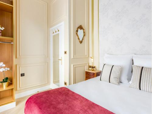 - une chambre avec un lit blanc et un tapis rouge dans l'établissement Merveil -Luxury Suite -Champs Elysees-Haussmann II, à Paris
