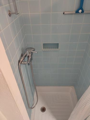 une douche avec un tuyau dans une salle de bain dans l'établissement T1 dans immeuble sur plage, au Grau-du-Roi