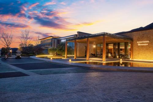 a building on a street with a sunset in the background at Joy Holiday Hotel Lijiang in Lijiang