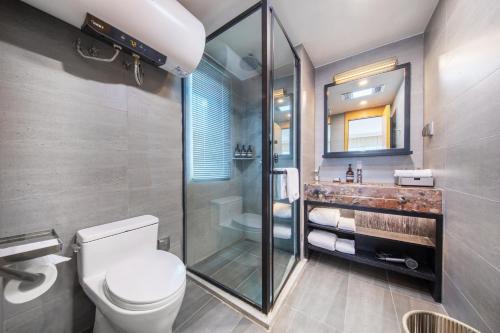 a bathroom with a toilet and a shower and a sink at Joy Holiday Hotel Lijiang in Lijiang