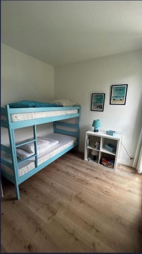 - une chambre avec un lit superposé bleu et une table dans l'établissement Maison en résidence avec piscine à 3m de la plage, à Carnac