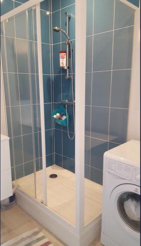 une douche dans une salle de bain avec machine à laver dans l'établissement Maison en résidence avec piscine à 3m de la plage, à Carnac