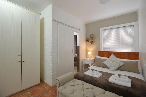 a bedroom with a bed with two towels on it at Urban Sole Beach House in Yzerfontein