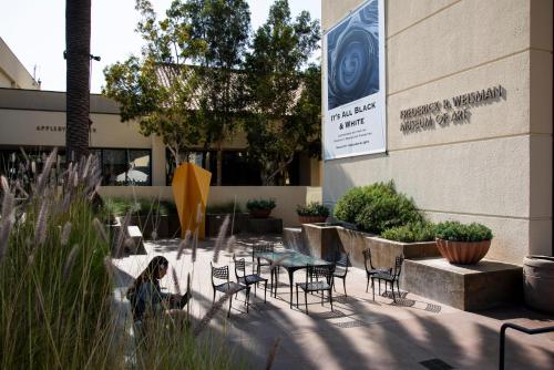 a person standing in front of a building with a table and chairs at Villa Graziadio Executive Center at Pepperdine University in Malibu