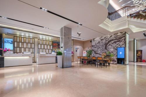 a lobby with a table and chairs in a building at Echarm Hotel Foshan Guangfo Road Jiaokou Metro Station in Foshan