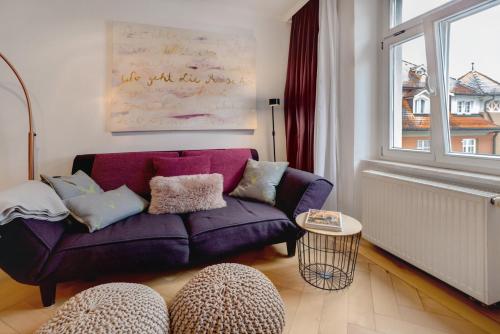a living room with a purple couch and a window at Alte Konditorei in Lindau