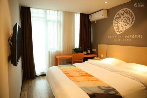 a hotel room with a bed and a window at Shell Nanjing Jiangning District University City Hotel in Nanjing
