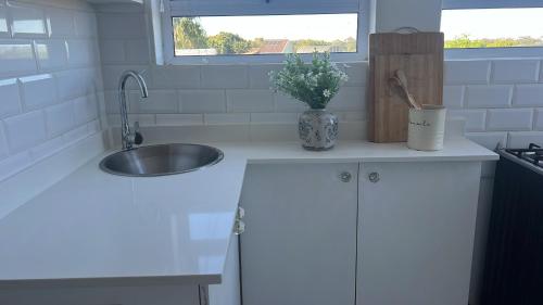 a kitchen with a sink and a vase of flowers on a counter at The White House in Port Elizabeth
