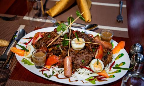 a plate of food with meat and vegetables on a table at KISIMANI ECO RESORT & SPA LTD in Isiolo