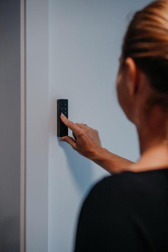a woman holding a cell phone up to a wall at Aprießnig Apartments in Fürnitz