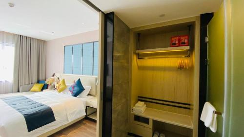a hotel room with a bed and a shower at Echarm Hotel Foshan Guangfo Road Jiaokou Metro Station in Foshan