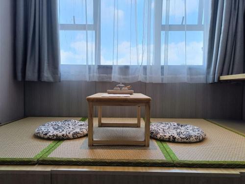 a table sitting on top of a room with two beds at Echarm Hotel Foshan Guangfo Road Jiaokou Metro Station in Foshan