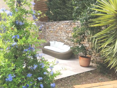 - un jardin avec un canapé, des plantes et des fleurs dans l'établissement Le Bastidon des Collines, à Aubagne
