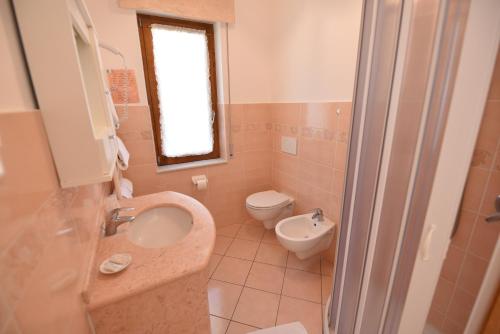a bathroom with a sink and a toilet and a window at Haidi House in Agerola