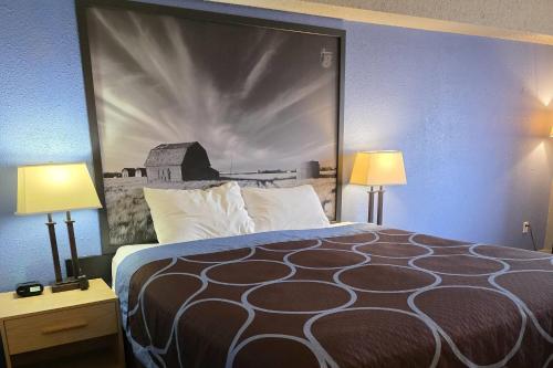 a large bed in a hotel room with two lamps at Super 8 by Wyndham Swift Current in Swift Current