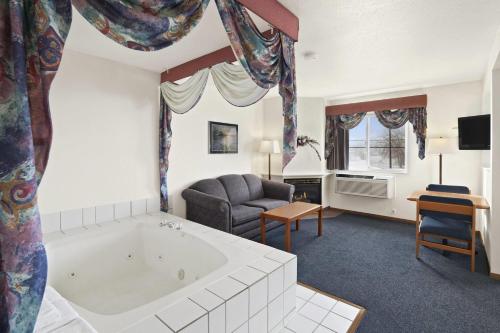 a large living room with a tub and a couch at Super 8 by Wyndham Swift Current in Swift Current