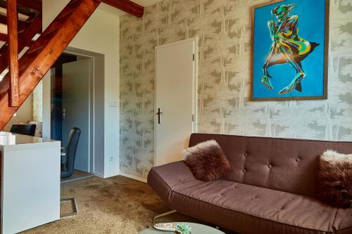 a living room with a couch and a painting on the wall at Luxury house in Krkonoše - Bukanda in Mladé Buky