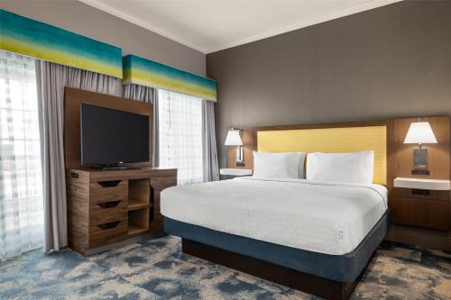 a bedroom with a bed and a flat screen tv at Hampton Inn & Suites Galveston in Galveston