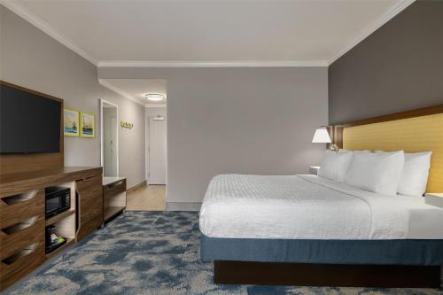 a hotel room with a bed and a flat screen tv at Hampton Inn & Suites Galveston in Galveston
