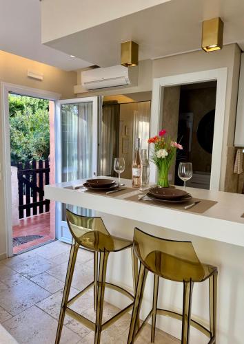 une cuisine avec un comptoir avec deux chaises et une table dans l'établissement Studio climatisé, terrasse, parking privé, 50m de la plage, à Saint-Tropez