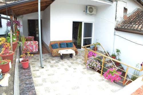 a patio of a house with a couch and flowers at Guesthouse Belle View Old Town in Berat