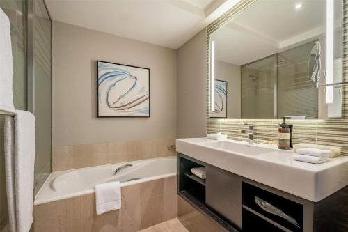 a bathroom with a tub and a sink and a bath tub at Hilton Sao Paulo Morumbi in Sao Paulo